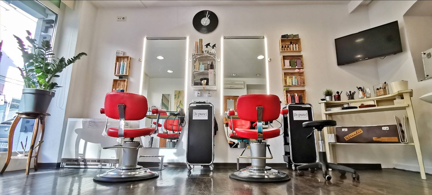 Zwei rote Friseurstühle mit [h:pure] Spiegelstationen